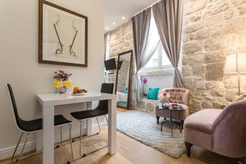 a living room with a table and a chair at Apartment and Rooms Stay in Dubrovnik