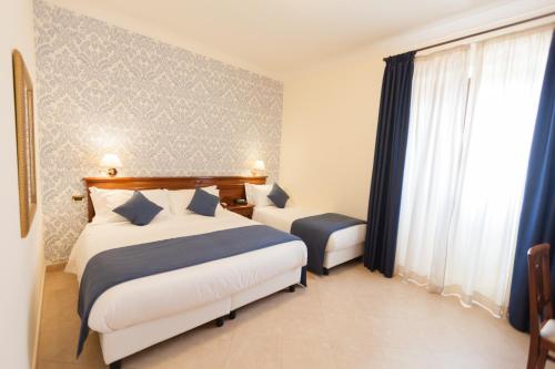 a hotel room with two beds and a window at Relais Villa Giuliana in Licata