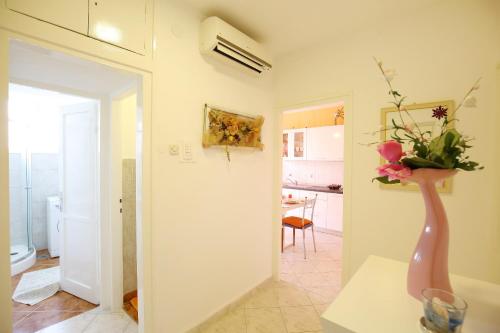 a room with a vase with flowers on a table at Apartment Angela in Zadar