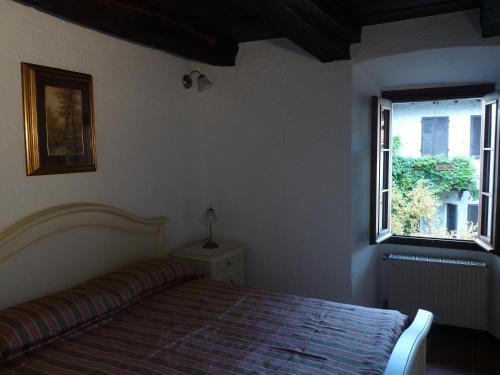 a bedroom with a bed and a window at Apartments Cusius and Horta in Orta San Giulio