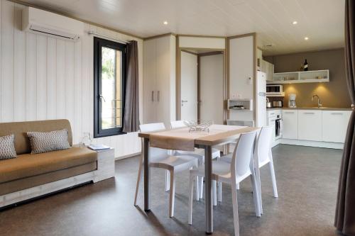 a kitchen and dining room with a table and chairs at Résidence & Hôtel Aria Marina in Propriano