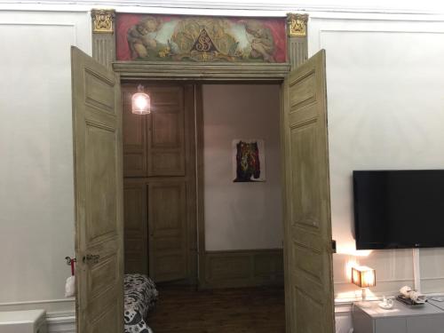 オーリヤックにあるle bal d'arsèneのテレビ付きの客室内の開放ドア