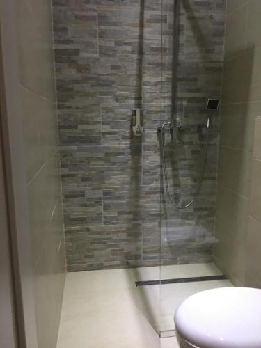 a bathroom with a glass shower with a toilet at Enjoyit Rooms in Velden am Wörthersee