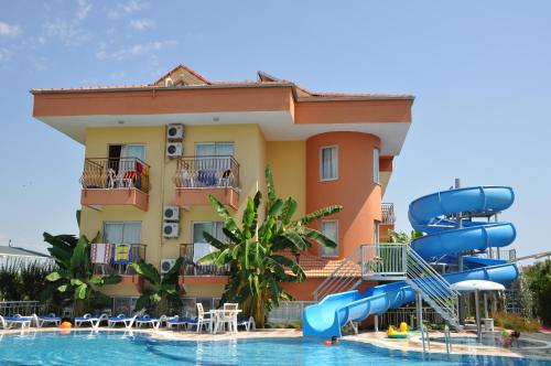 a pool with a slide in front of a hotel at Yavuzhan Hotel in Side