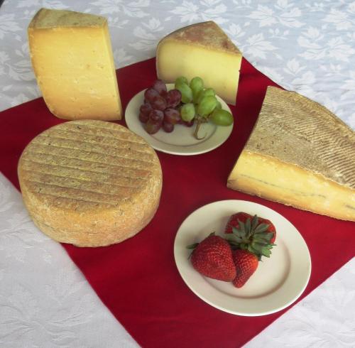 a tray of different types of cheeses and strawberries at Red Top Motor Inn in Iron Bridge