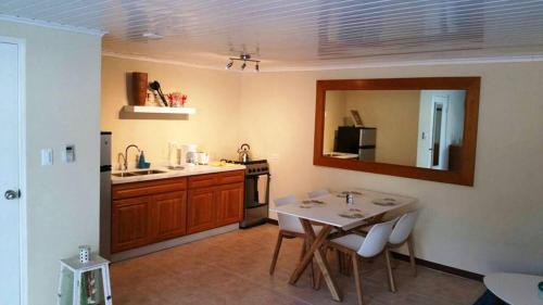 a kitchen with a table and a sink and a mirror at Sandpiper Beach Apartments in Palm-Eagle Beach