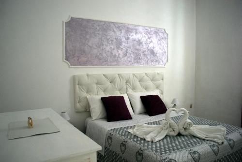 パチェーコにあるLe Gemmeのベッドルーム1室(紫色の絵画が壁に描かれたベッド1台付)