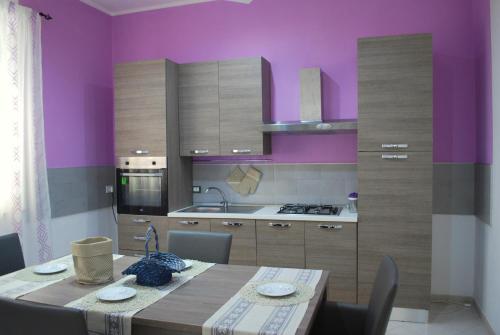 パチェーコにあるLe Gemmeの紫の壁のキッチン(テーブル付)