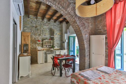 uma cozinha com uma mesa num quarto com uma parede de pedra em Mare amore @ Riomaggiore em Riomaggiore