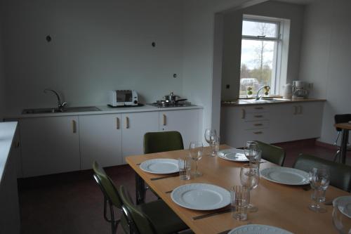 a dining room with a table and chairs and a kitchen at Eidavellir Apartments and Rooms in Egilsstadir