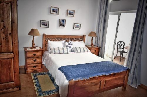 a bedroom with a large bed with a blue blanket at Bella's House in Évora