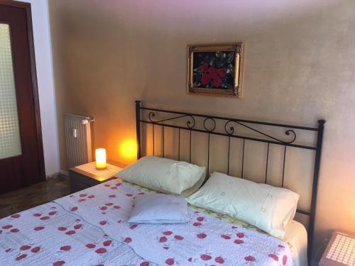 アルビソーラ・スペリオーレにあるCasa Elenaのベッド1台(枕2つ付)、壁に絵が描かれています。