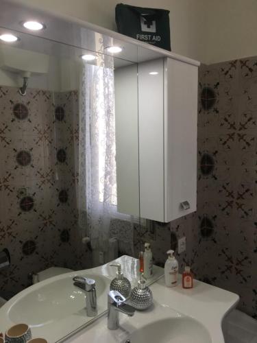y baño con lavabo blanco y espejo. en Casa Elena, en Albisola Superiore