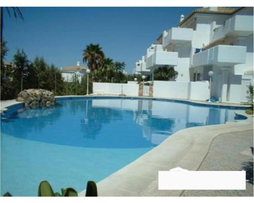 a large blue swimming pool in front of a building at Casa Sargo in Chiclana de la Frontera
