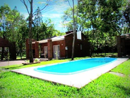 ein großer blauer Pool vor einem Haus in der Unterkunft Cabañas Punta Fabiana in Resistencia