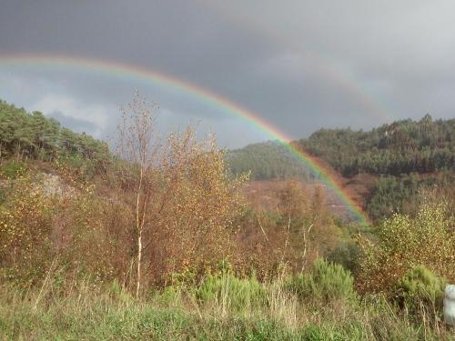 a rainbow in the middle of a field at Pensión NAVIA A Pontenova in A Pontenova