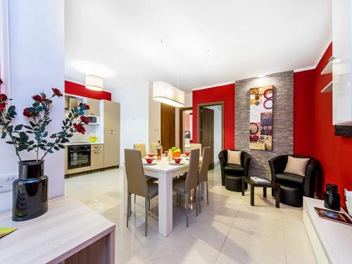 a kitchen and dining room with a table and chairs at Bayside Apartments in St Julian's