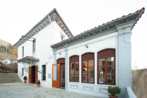 a white building with brown doors and windows at La Castellana - Habitaciones y desayuno in Benasal