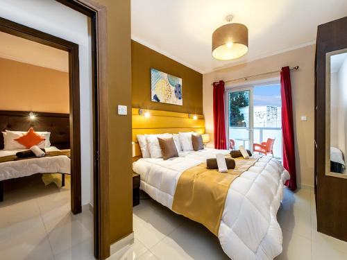 a hotel room with a large bed and a window at Bayside Apartments in St Julian's