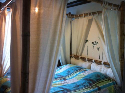 a bedroom with a canopy bed with palm trees on it at Ferme du Montheu in Dommartin-sous-Amance