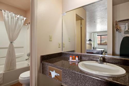 a bathroom with a sink and a toilet and a mirror at The Noor Hotel in Torrey