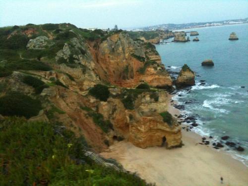 a rocky coastline with a beach and the ocean at Good Vibes - Lagos Guesthouse in Lagos