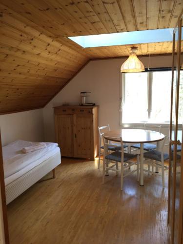 a bedroom with a table and a bed and a table and chairs at Idöborgs Stuguthyrning in Nämdö