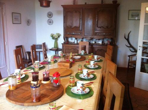 - une table en bois avec de la nourriture dans la cuisine dans l'établissement Ferme du Montheu, à Dommartin-sous-Amance