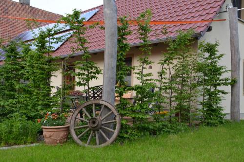 an old wagon wheel in the yard of a house at Ferienappartements "Landromantik" in Bautzen