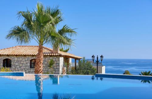 a swimming pool with a palm tree next to a building at Marni Village in Hersonissos