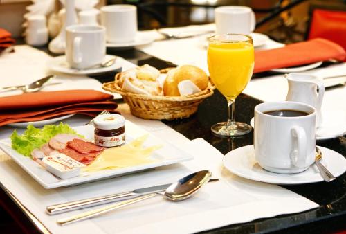 
a table topped with a plate of food and a cup of coffee at Hotel Korston Royal Kazan in Kazan

