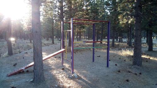 un parque de juegos vacío en un parque con árboles en Paralelo 42° Lodge, en El Maitén
