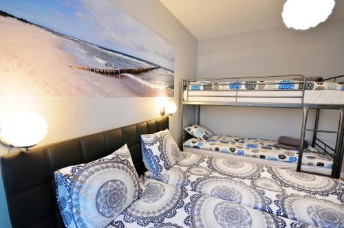 sypialnia z 2 łóżkami piętrowymi i obrazem w obiekcie Luxury Marina Apartment w Kołobrzegu