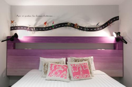a bed with a purple headboard and some pillows at La Palomilla Bed & Breakfast in Mexico City