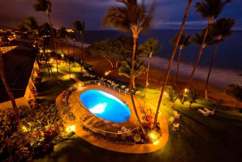 an overhead view of a swimming pool at the beach at night at The Hale Pau Hana in Kihei