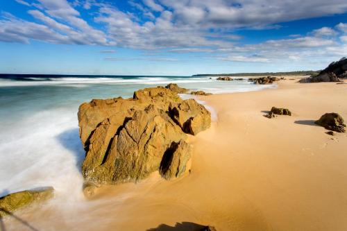 a large rock in the sand on a beach at BIG4 Moruya Heads Easts Dolphin Beach Holiday Park in Moruya