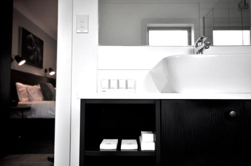 a bathroom with a white sink and a mirror at Kelly Rd Cambridge Lodge in Cambridge
