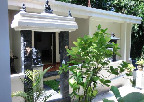 um edifício com uma fonte num jardim em Latugu Homestay Ubud em Ubud