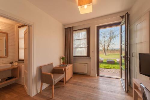a room with a window and a chair and a television at Podere del Priorato in Albinia