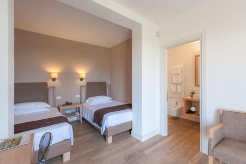 a hotel room with two beds and a couch at Podere del Priorato in Albinia