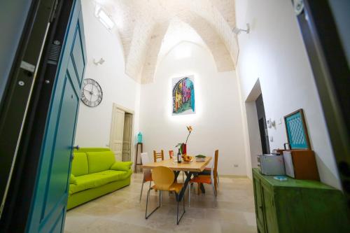 a living room with a table and a green couch at Dafne in Ostuni