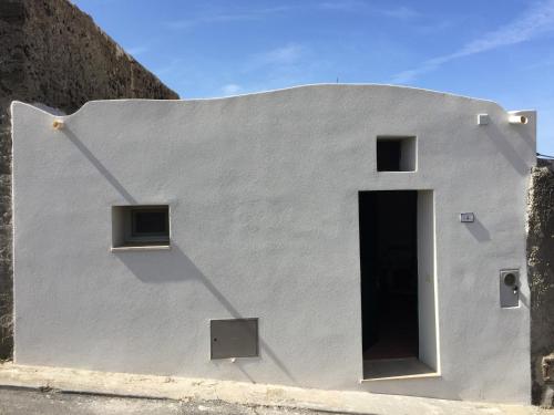 ein weißes Gebäude mit einer Seitentür in der Unterkunft Studio Alli in Pantelleria