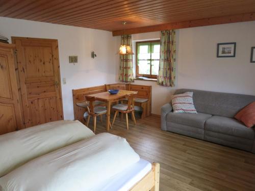 a bedroom with a bed and a couch and a table at Ferienhof Landhaus Michael in Böbrach