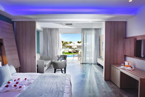 ein Hotelzimmer mit Bett und Wohnzimmer in der Unterkunft Pernera Beach Hotel in Protaras