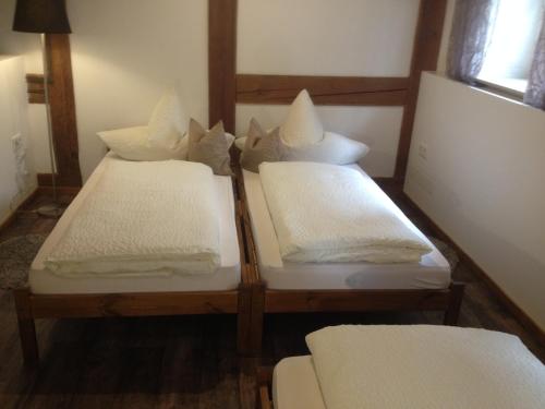 a group of three beds in a room at Die kleine Pension in Gößweinstein