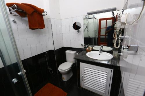 a bathroom with a white toilet and a sink at Peradeniya Rest House in Kandy