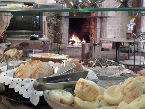 Una mesa con un montón de pasteles y una chimenea. en Pousada Sonho Meu Foz, en Foz do Iguaçu