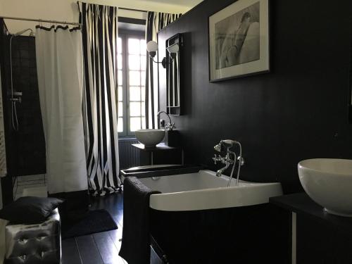 bagno nero con vasca e lavandino di Le Domaine de Cordey a Boucé