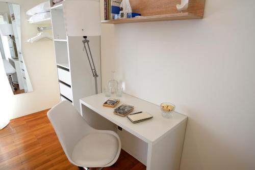 a white desk with a chair in a room at Mid Mod in Cantù