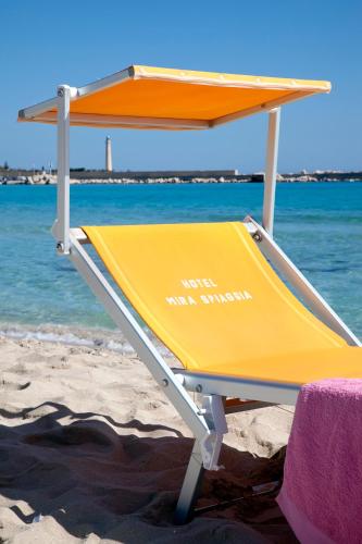 a yellow beach recliner on the beach at Mira Spiaggia in San Vito lo Capo